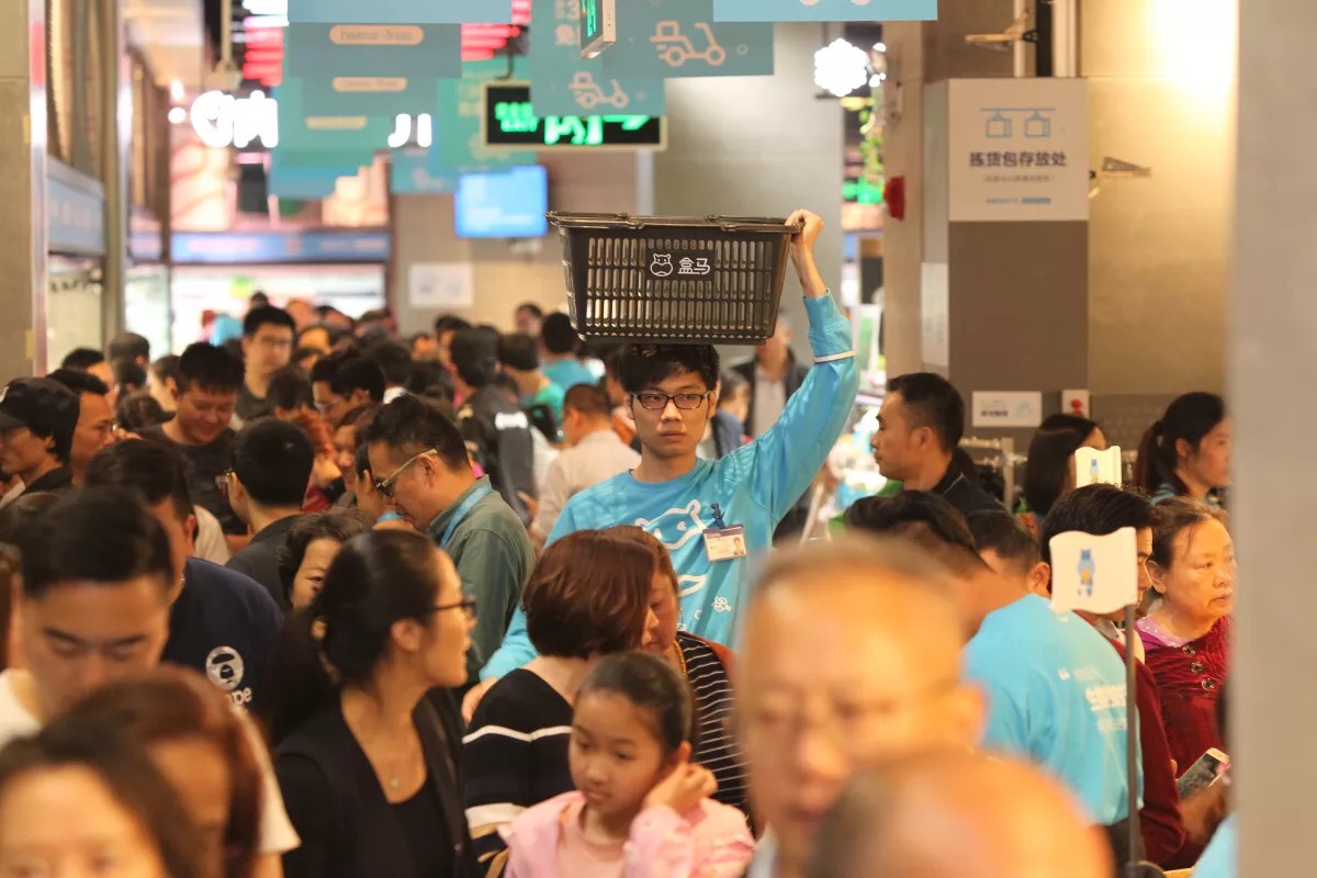 盒马深圳信和店开业客流爆满,服务人员把购物筐顶在头顶